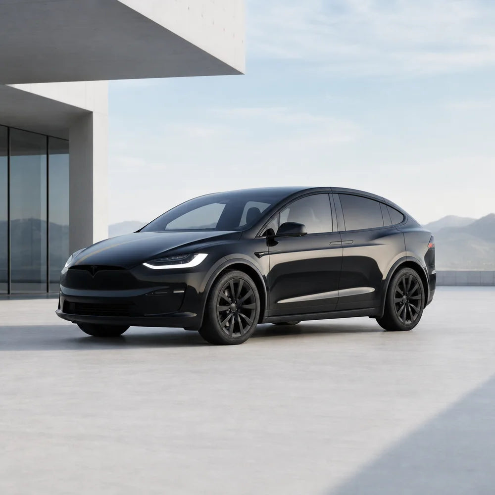 Black Tesla Model X outside a modern home