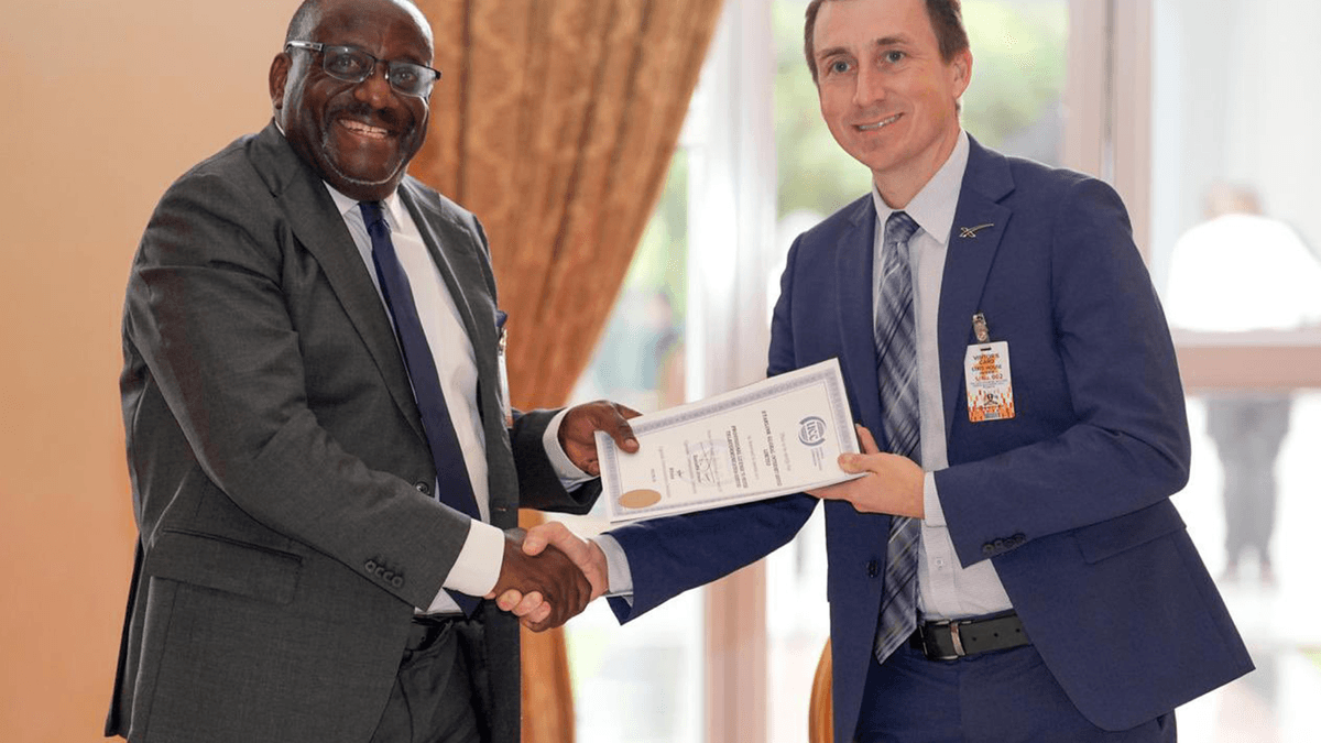 Uganda Communications Commission official and Starlink representative display a licensing document
