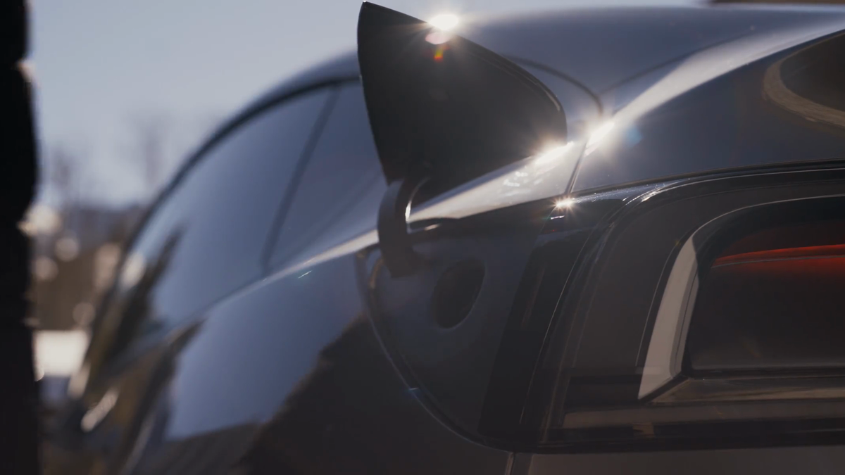 Tesla vehicle charge port open in an outdoor cold-weather setting